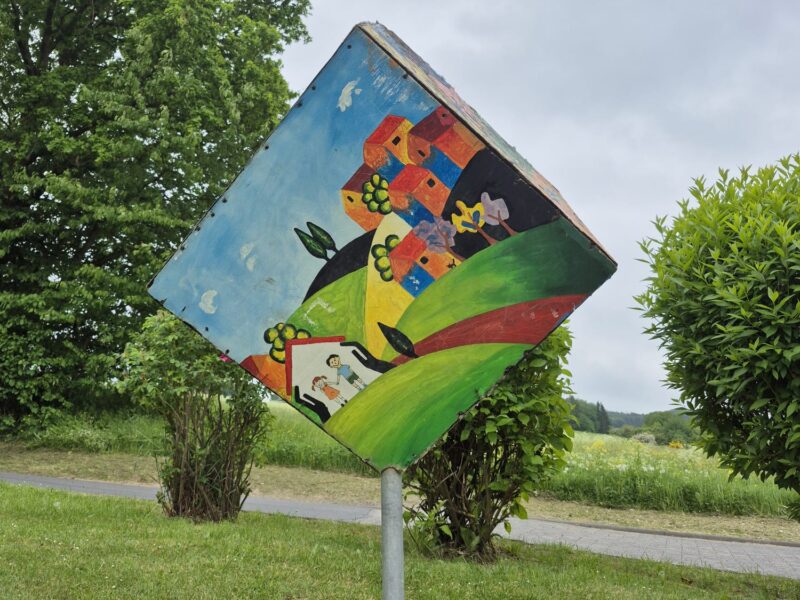 Bemalte Holztafel einer Station des Kinderrechtepfads