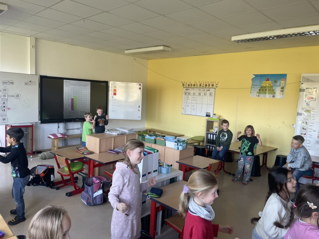 Kinder arbeiten gemeinsam im Klassenraum der Regenbogenschule