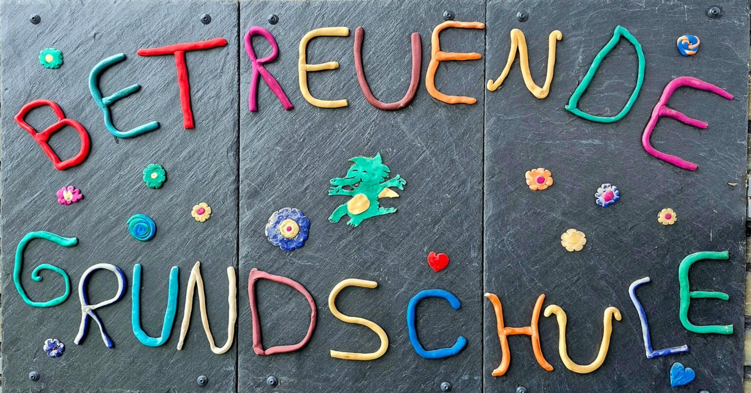 Schild der Betreuenden Grundschule, von Kindern aus buntem Ton gestaltet
