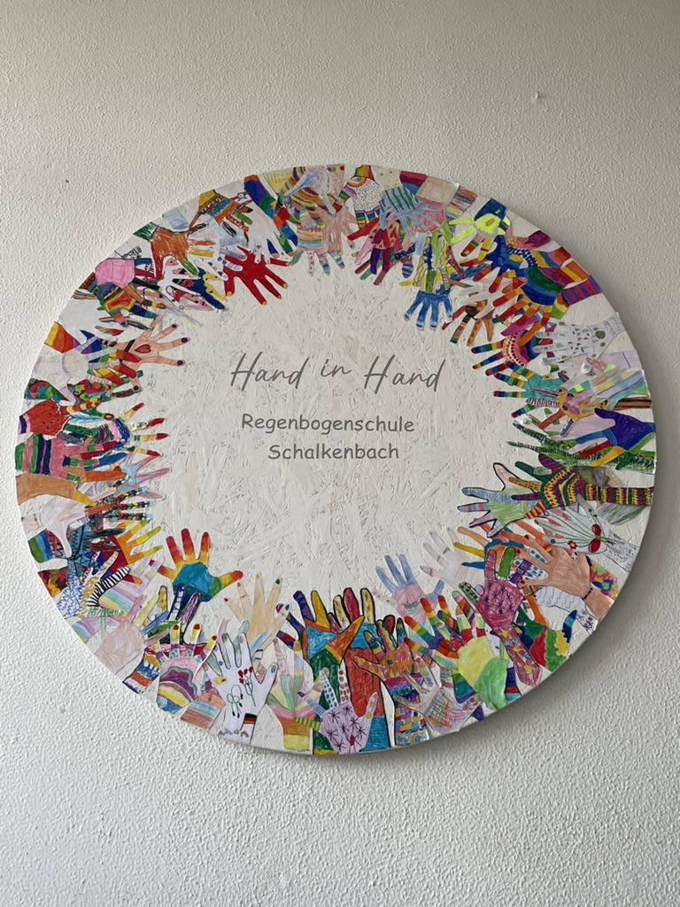 Wandbild Hand in Hand aus bunten Handabdrücken der Kinder